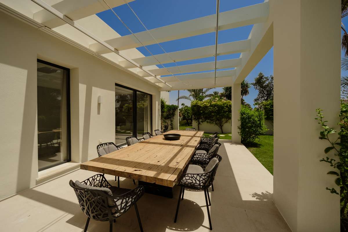 Comedor exterior bajo pérgola